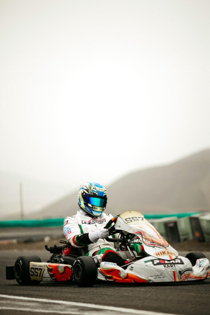 Dynamic shot of a racer in full gear during an outdoor go-kart competition.